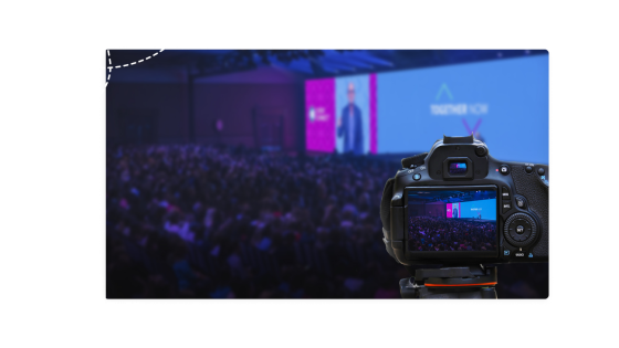 A camera is capturing an event with a crowd of people.